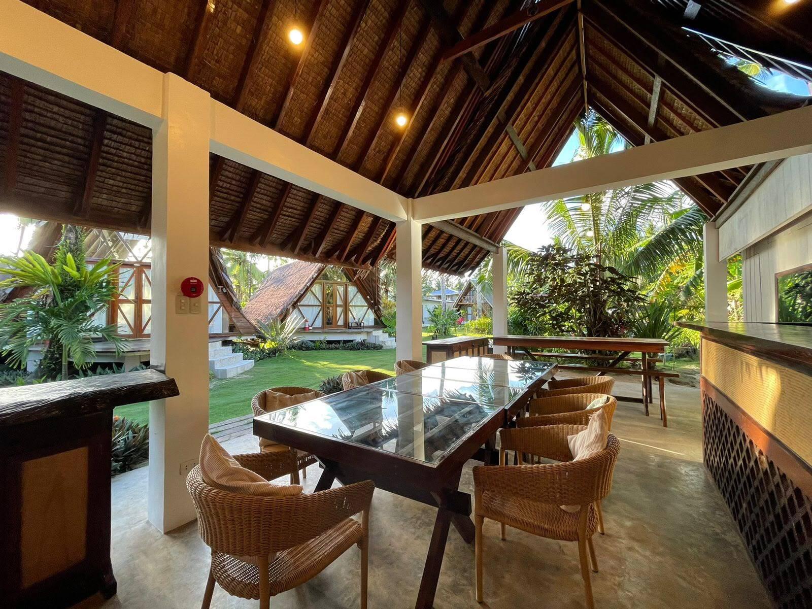 Open lounge with wooden furniture under a thatched roof